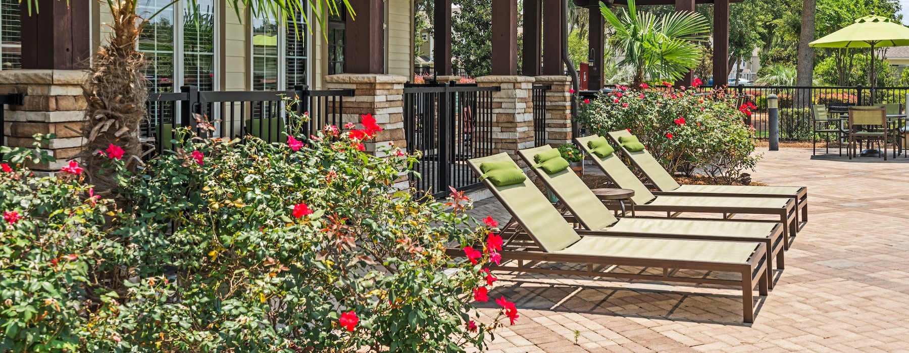 a patio with a bench and flowers
