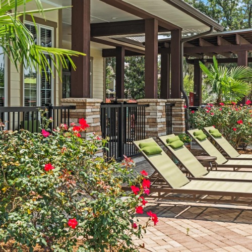 a patio with a bench and flowers